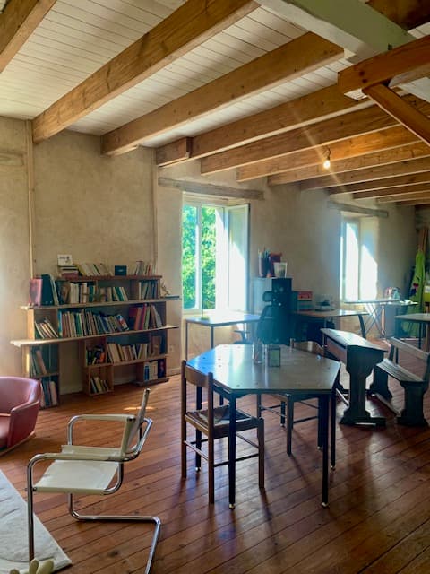 Bibliothèque et grande table de la salle de coworking